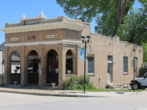 The buff-brick 1907 bank at 188 South Main, with four arched openings and BANK and A·1907·D on the parapet